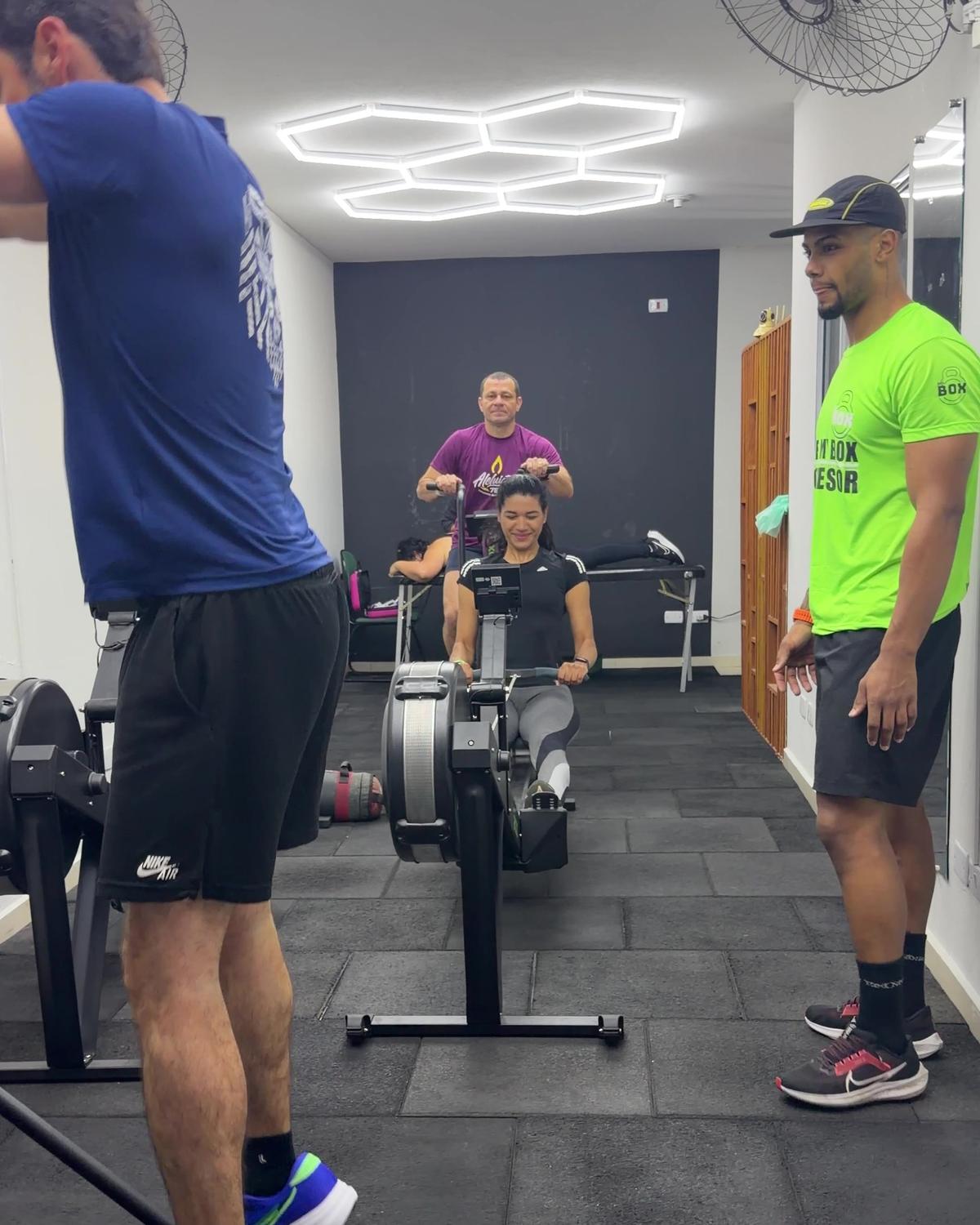 Dois professores do MyBox acompanhando de perto um aluno em esforço no ergômetro
